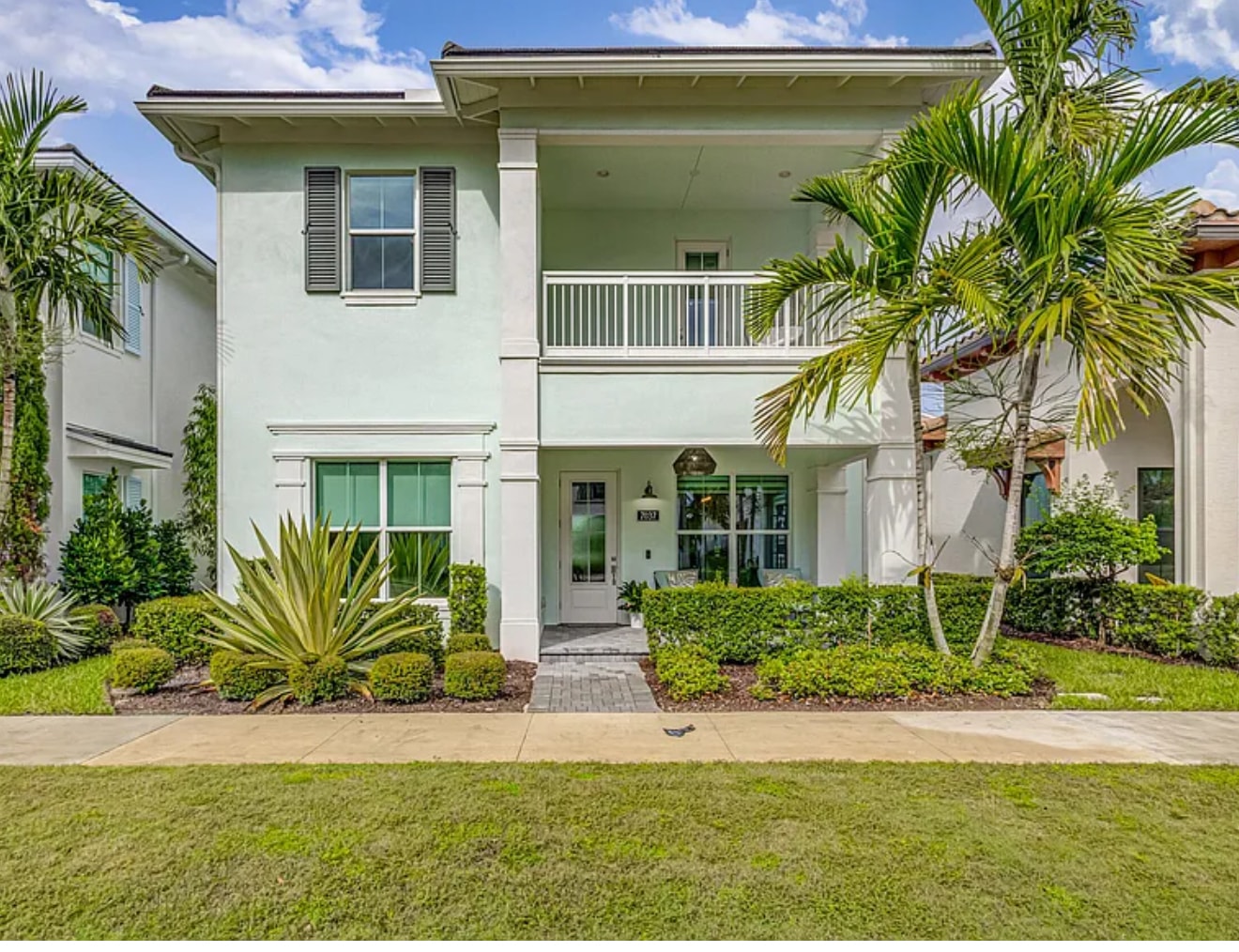 Modern white two-story home with tropical landscaping, Palm Beach County